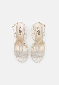 Silver strappy sandals with a textured herringbone pattern, a cushioned golden insole, and an adjustable ankle buckle.