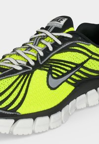 Νεον κιτρινό και μαύρο παπούτσι running Nike Skylon 11 με λευκά κορδόνια και λευκή διαχωρισμένη σόλα.