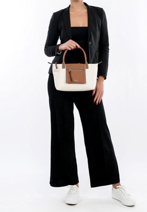 Sac à main blanc et beige avec une poche zippée, des poignées en cuir et un corps en tissu doux. Le sac présente une forme rectangulaire et des coutures subtiles.