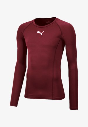 Long-sleeve athletic shirt in maroon, made of smooth, stretch fabric featuring a white Puma logo on the chest and flatlock seams.