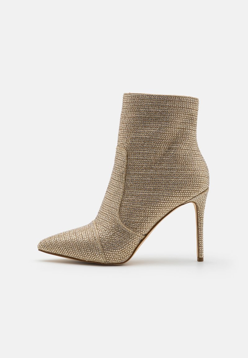 Bottine beige à bout pointu et talon stiletto, ornée de petites décorations scintillantes.