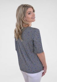 Korte mouwen top van lichtgewicht stof met een geometrisch patroon in marineblauw, wit en multikleurige accenten; ontspannen pasvorm en afgeronde achterkant.