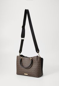 Braune Handtasche mit schwarzen Akzenten, verfügt über ein geometrisches Muster, zwei obere Griffe und einen abnehmbaren schwarzen Schultergurt. Goldfarbene Hardware-Details.