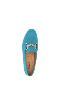 Turquoise suède mocassin met een platte ontwerp, gouden hardware details en geperforeerde binnenzool. Merkennaam "Gabor" is gedrukt aan de binnenkant.