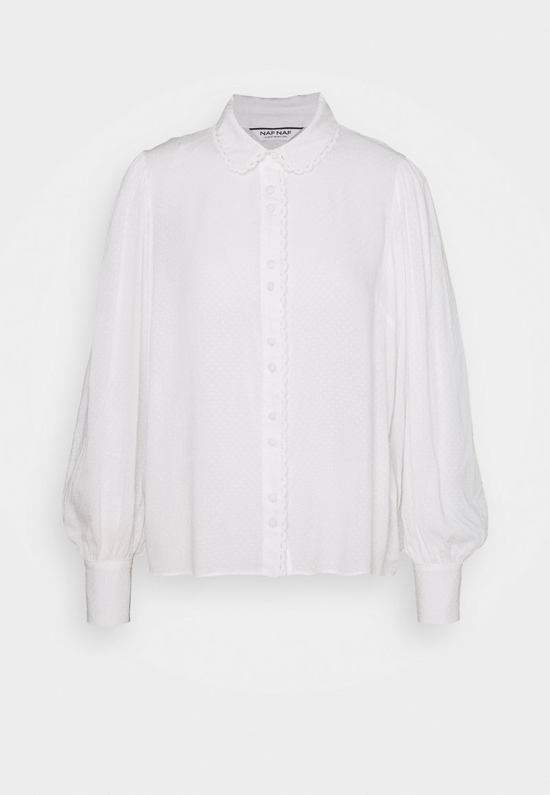 Blouse blanche à manches longues avec col claudine festonné, fermeture boutonnée devant avec bord festonné et poignets froncés.