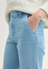 Ljusblå denimjeans med slim fit, femficksdesign och rak benform. Tyget har en jämn textur med subtila blekningar.