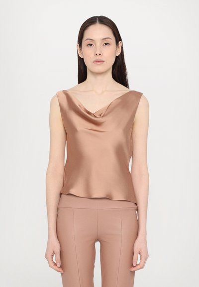 Top à col drapé en satin de couleur marron clair, sans manches, avec une texture lisse, tombant doucement sur le corps, associé à un pantalon ajusté assorti.