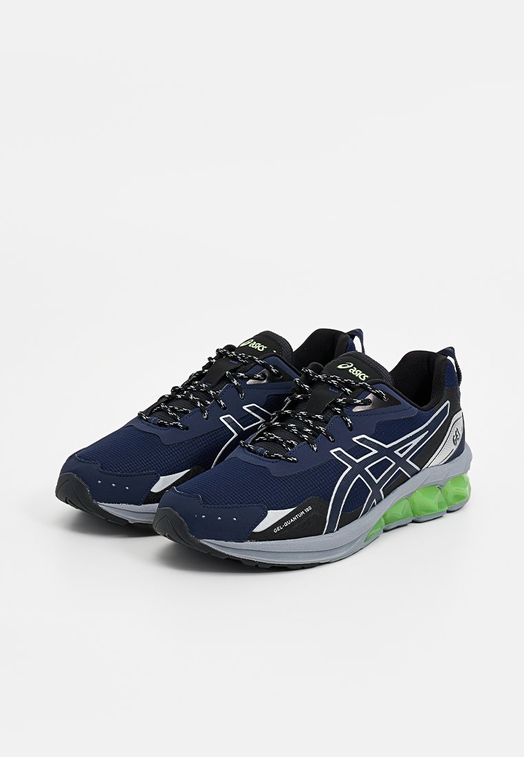 Un paio di scarpe da corsa ASICS blu navy con lacci neri, strisce laterali bianche, suole grigie e ammortizzazione in gel verde brillante.