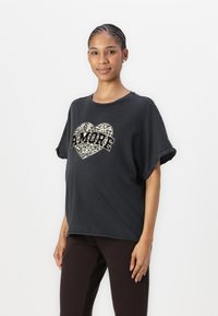 Černé oversized tričko s leopardím vzorem srdce a tučným nápisem "AMORE". Krátké, ohrnuté rukávy. Měkký, bavlněný materiál.