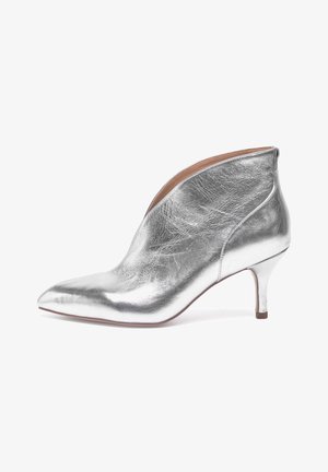 Stivaletto alla caviglia argento realizzato in pelle metallica, caratterizzato da una punta appuntita, un design elegante e un tacco sottile. Texture liscia senza motivi visibili.