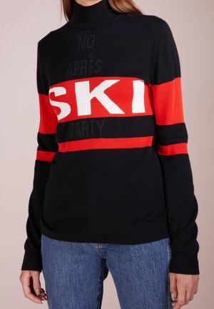 Maglione nero lavorato a maglia con strisce orizzontali rosse e bianche, con la scritta "SKI" in evidenza. Design colletto alto, texture morbida, polsini a costine.