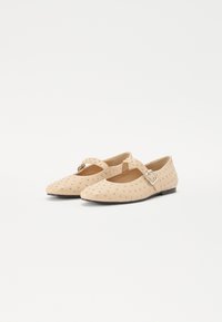 Scarpe flat beige con design a punta, caratterizzate da una cinturini con fibbia e decorazioni borchiate sulla superficie superiore.