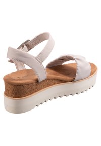 Lichtgrijze platform sandaal met kurken voetbed, zachte stoffen banden en een getextureerde rubberen zool. Verstelbare enkelband voor een veilige pasvorm.