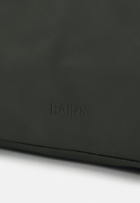 Borsa verde scuro realizzata in materiale impermeabile, con una texture liscia e il logo "RAINS" in rilievo. Design minimalista senza hardware visibile.