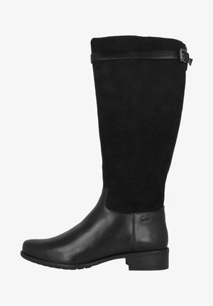Botas negras hasta la rodilla con una combinación de cuero liso y ante suave, que presentan una correa decorativa negra con una hebilla plateada en la parte superior.
