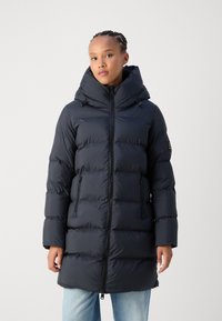 Abrigo de plumas azul marino con cuello alto, bolsillos laterales con cremallera, diseño de acolchado horizontal y capucha con cordón. Tejido suave e insulated.