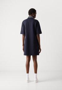 Navy, short-sleeve dress with a collar featuring white stripes. Straight cut and knee-length, made from a smooth fabric.