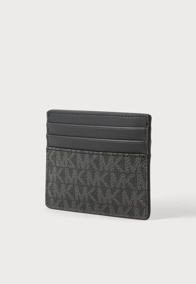 Porte-cartes noir avec motif texturé et trois emplacements pour cartes sur un fond clair uni.