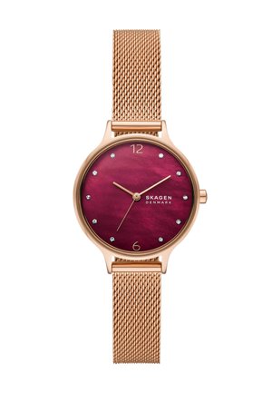 Rose gold mesh strap watch with a round burgundy face, gold hands, crystal hour markers, and Skagen Denmark branding.