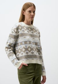 Knit sweater in cream with beige and light blue geometric patterns, featuring ribbed neckline and cuffs, relaxed fit, and soft texture.