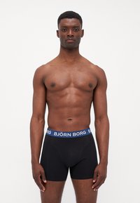 Boxeri negri cu un elastic albastru pe care este logo-ul "BJÖRN BORG". Materialul pare a fi moale și elastic, completând designul ajustat.