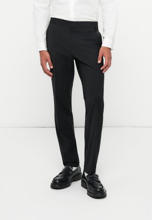 Zwarte getailleerde broek met een gladde textuur en slim fit, voorzien van een vlakke voorkant en zijzakken, gecombineerd met gepolijste zwarte schoenen.