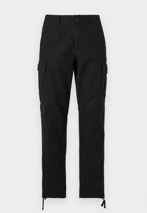 Mustat suorat leggin cargo-housut, joissa edessä nappi ja vetoketju, sivutaskut läpällä, vyölenkit ja säädettävät nilkan kiristysnauhat.