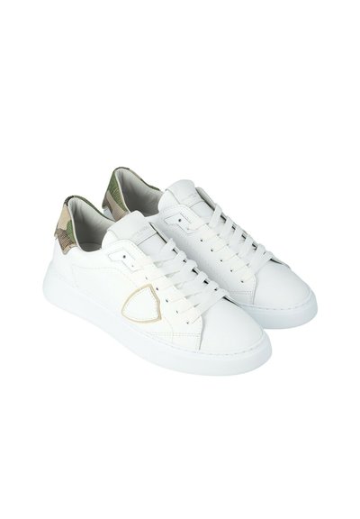 Een paar witte low-top sneakers met witte veters en een groen camouflagepatroon op de hielTabs, weergegeven op een witte achtergrond.