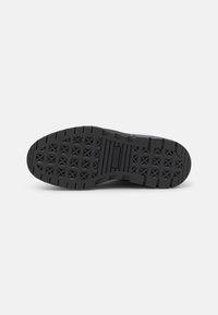 Sole di scarpa in gomma nera con un motivo gommato testurizzato a forma di stella, progettata per trazione e durata. Bordo liscio e finitura solida.