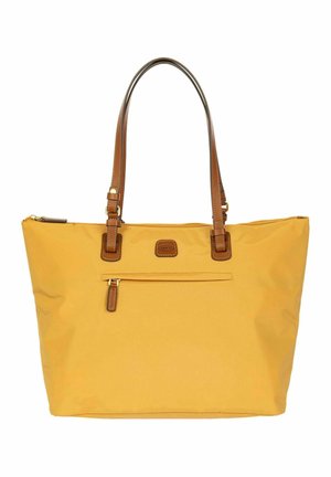 Gele tote tas met bruine leren handvatten, voorvak met rits en een gebrandmerkte leren patch, ontworpen voor dagelijks gebruik.