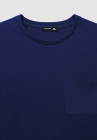 T-shirt in cotone blu navy con scollatura rotonda, maniche corte raglan e taschino sul lato sinistro del petto. Texture liscia, design minimal. Taglia XL.