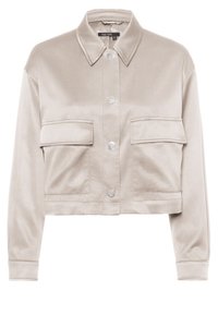 Helle beige, kurz geschnittene Jacke mit Kragen, zwei Vorderaschen und silbernen Druckknöpfen; aus glattem, strukturiertem Stoff gefertigt.