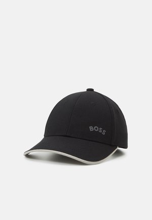 Sort baseballkasket med buet skygge med hvid kant og "BOSS" logo på frontpanelet, vist på hvid baggrund.