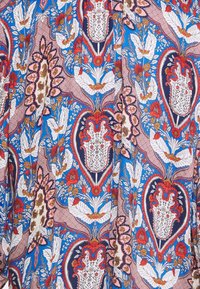 Tessuto con un motivo floreale e paisley nei colori blu, rosso, rosa e bianco. Texture liscia con dettagli intricati e colori vivaci.