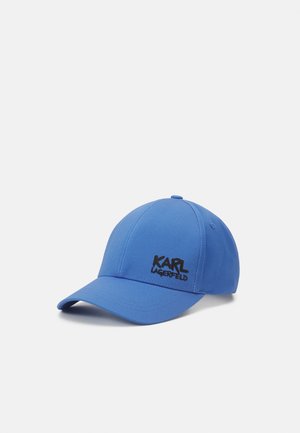 Blauwe honkbalpet met zwart "KARL LAGERFELD" logo aan de voorkant, afgebeeld tegen een effen lichtgrijze achtergrond.