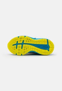 Suola di scarpa sportiva in blu e giallo. Il motivo del battistrada presenta scanalature e forme esagonali per una migliore aderenza. Materiale in gomma resistente.