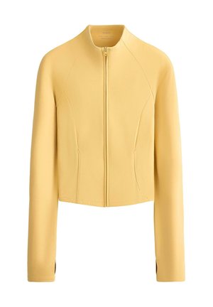 Világos sárga, rövidített kabát hosszú ujjakkal, elülső cipzárral és karcsúsított szabással.