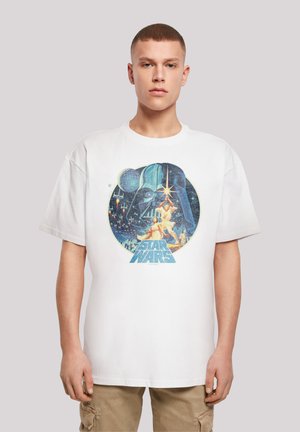 White cotton t-shirt featuring a colorful Star Wars graphic print, depicting a character with a lightsaber and the text "STAR WARS" in blue.