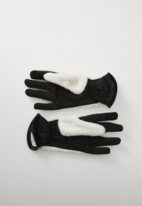 Une paire de gants d'hiver noir et blanc avec des accents en fausse fourrure et des sangles de poignet ajustables, posée à plat sur une surface blanche.