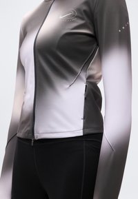 Αθλητικό μπουφάν Nike με φερμουάρ, με διαβάθμιση από σκούρο γκρι σε ανοιχτό γκρι, φτιαγμένο από λείο ύφασμα με αντανακλαστικό λογότυπο και λεπτομέρειες.