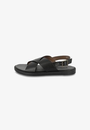 Sandalo in pelle nera con design a strappo incrociato, chiusura con fibbia regolabile, suola piatta e dettagli testurizzati sulla superficie della suola.