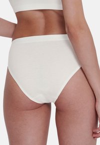 Witte katoenen hoogstaande slipjes met een zachte tailleband, een gladde textuur en een klassieke snit, bekeken vanuit de achterkant.