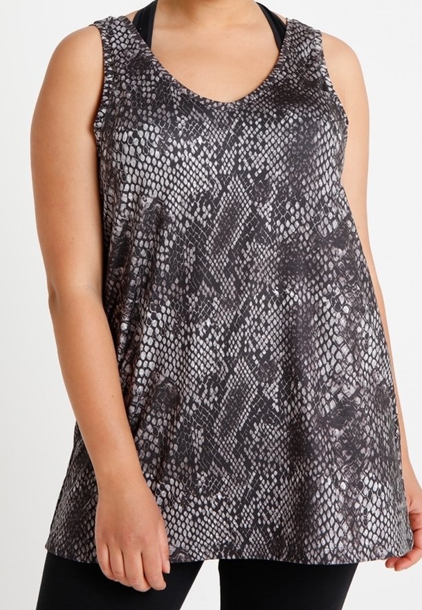 Femme portant un débardeur noir et gris imprimé serpent sans manches sur un soutien-gorge de sport noir, associé à un legging noir.