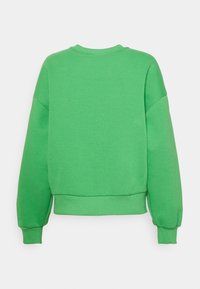 Sudadera verde con escote redondo, hombros caídos, puños acanalados y cinturilla. Fabricada con un tejido suave y texturizado. Vista trasera solamente.