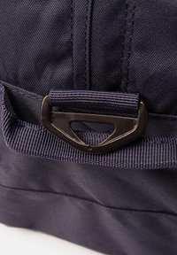 Borsa in tessuto blu navy con finitura testurizzata, dotata di una clip metallica nera e dettagli in nastro per un attacco sicuro.