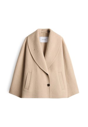 Manteau court en laine beige avec un large col châle, deux poches latérales et deux boutons sombres, étiqueté "OPUS" à l'intérieur du col.