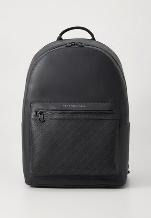 Černý batoh s hladkým povrchem a geometricky vzorovanou přední kapsou. Obsahuje horní ucho a dvojité zipy. Minimalistický design.