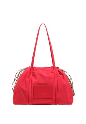 Bolsa de tela roja con parte superior fruncida, asas largas y un parche de cuero rectangular con marca en relieve. Textura suave con un diseño minimalista.
