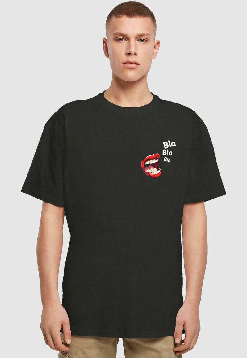 Camiseta de algodón negra con un gráfico de labios rojos y el texto "Bla Bla Bla" en blanco. Corte holgado con mangas cortas.