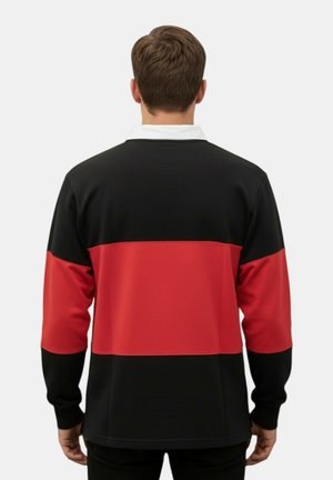 Uomo che indossa una maglia da rugby a maniche lunghe nera e rossa con un colletto bianco, visto di spalle su uno sfondo chiaro uniforme.
